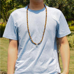 Load image into Gallery viewer, Buddha Courage 108 Mala Beads wear as necklace on man model in garden
